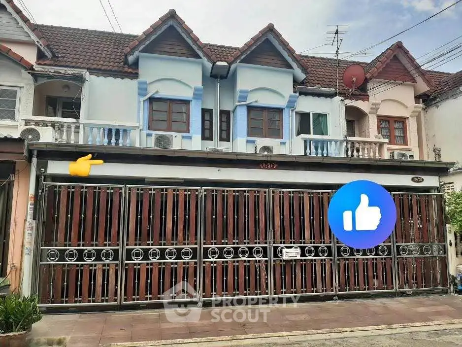 Charming townhouse with unique facade and gated entrance in a residential area.