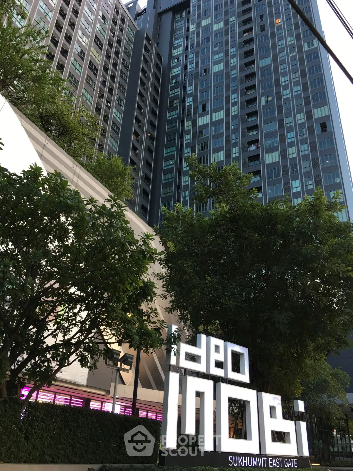 Modern high-rise building with lush greenery at Ideo Mobi Sukhumvit East Gate.