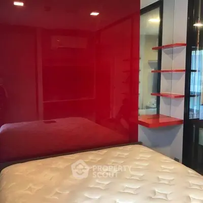Modern bedroom with red accent wall and sleek shelving