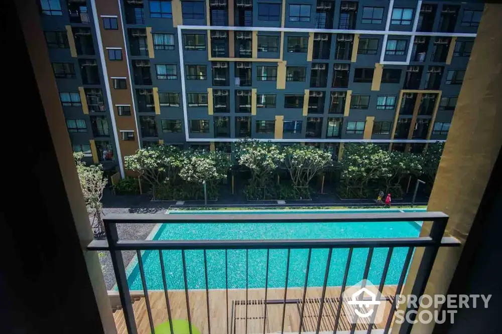 Modern apartment view with pool and lush greenery from balcony