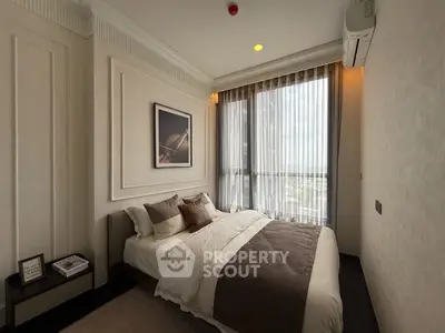 Luxurious bedroom with elegant decor and large window offering natural light.