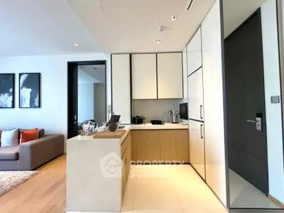 Modern open-layout kitchen with sleek cabinetry and cozy living area