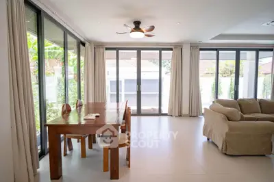 Spacious living room with large windows and modern furniture, perfect for family gatherings.