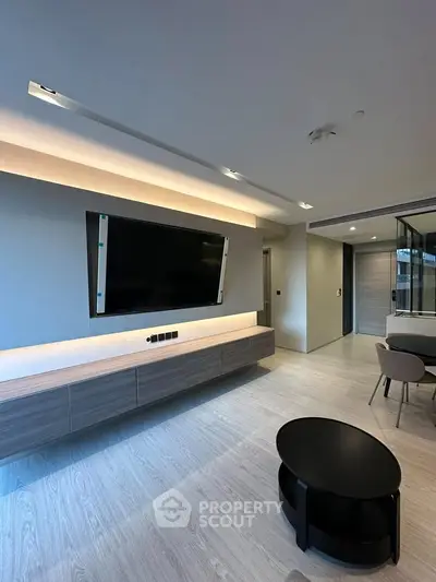 Modern living room with sleek TV setup and stylish furniture in a contemporary apartment.