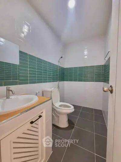 Modern bathroom with sleek design and green tile accents