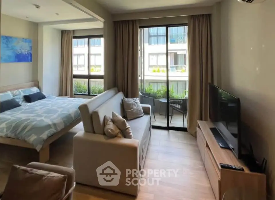 Modern studio apartment with cozy living area and balcony view