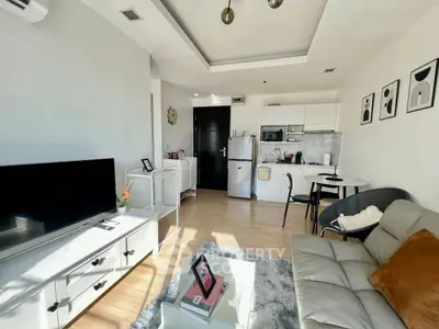 Modern living room with open kitchen, stylish decor, and natural light in a cozy apartment.