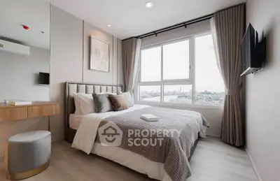 Modern bedroom with large window offering stunning city view, elegant decor, and cozy ambiance.