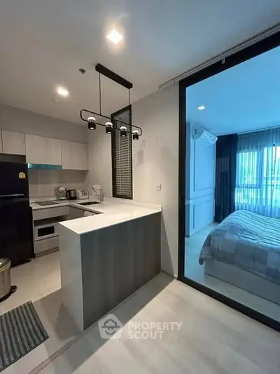 Modern kitchen with sleek design and adjacent bedroom view