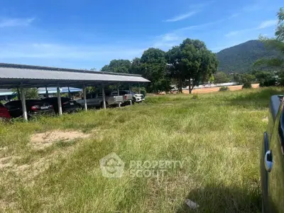 Spacious outdoor parking area with scenic mountain backdrop and lush greenery.