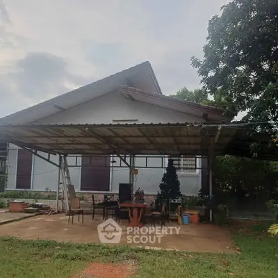Charming single-story house with spacious covered patio and lush greenery, perfect for outdoor relaxation.
