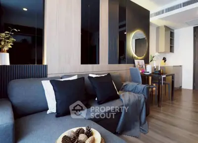 Modern living room with stylish decor and open dining area, featuring sleek furniture and ambient lighting.