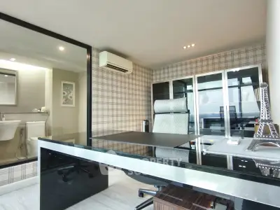 Modern study room with glass desk and elegant decor in a stylish apartment.