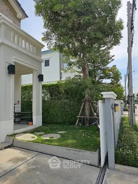 Charming garden entrance with lush greenery and modern architecture