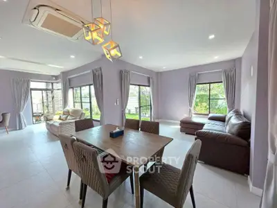 Spacious modern living room with elegant dining area and large windows offering natural light.