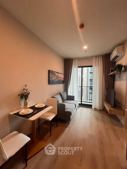 Modern living room with cozy seating and balcony view in stylish apartment.