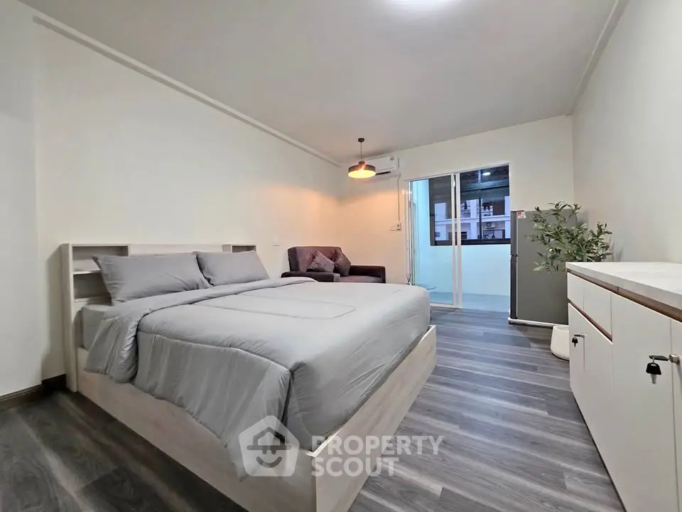 Modern bedroom with sleek design and balcony access in urban apartment
