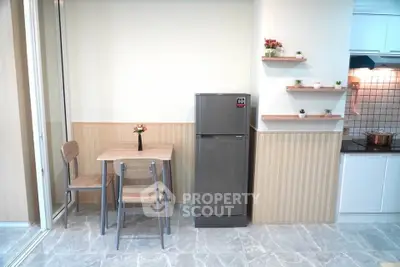 Charming kitchen with modern fridge and cozy dining area, perfect for small spaces.