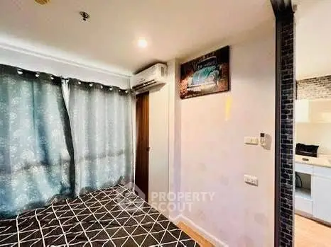 Cozy bedroom with modern decor and natural light, featuring stylish curtains and a glimpse of a contemporary kitchen.
