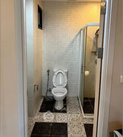 Modern bathroom with shower and toilet, featuring stylish tile design.