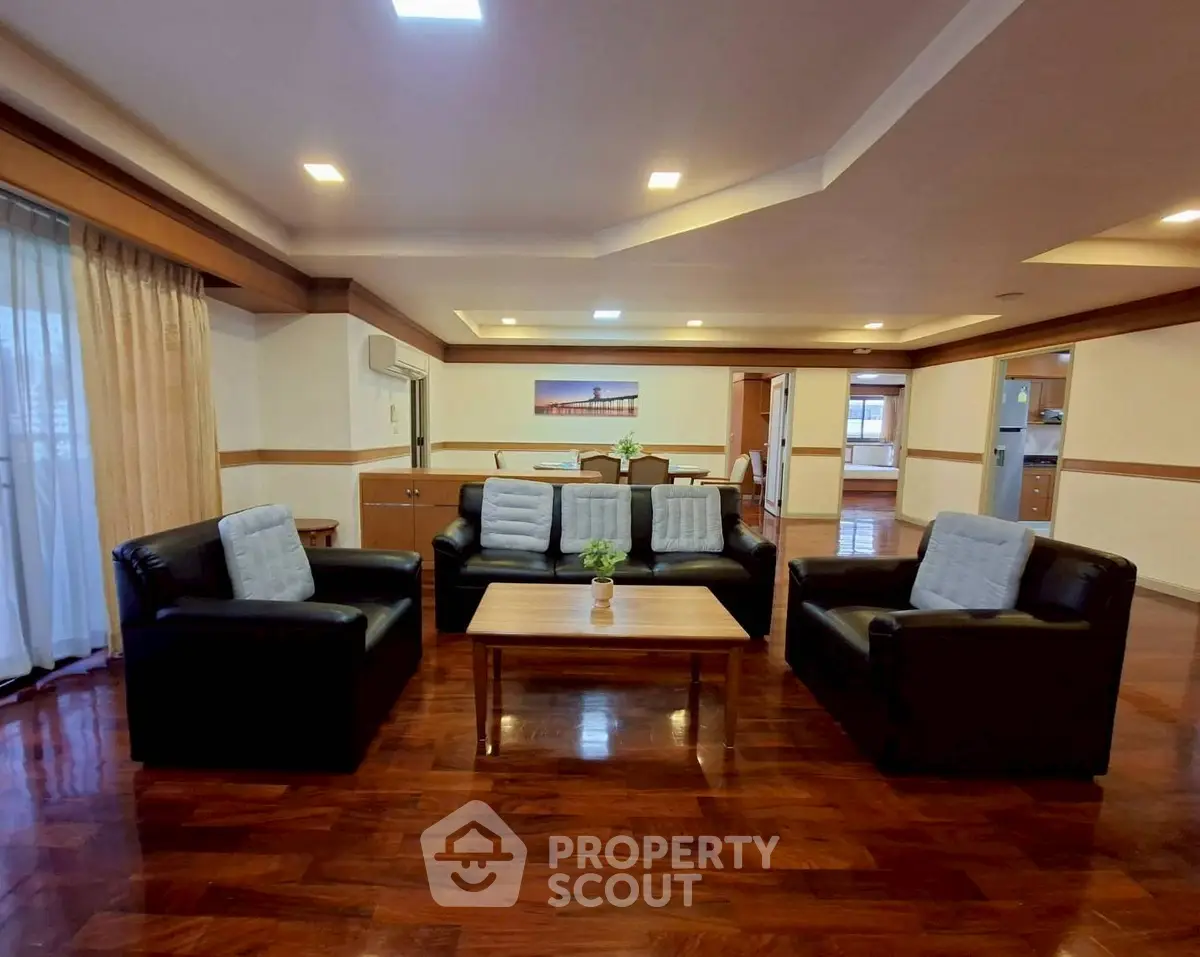 Spacious living room with elegant wooden flooring and modern furniture in a luxurious apartment.