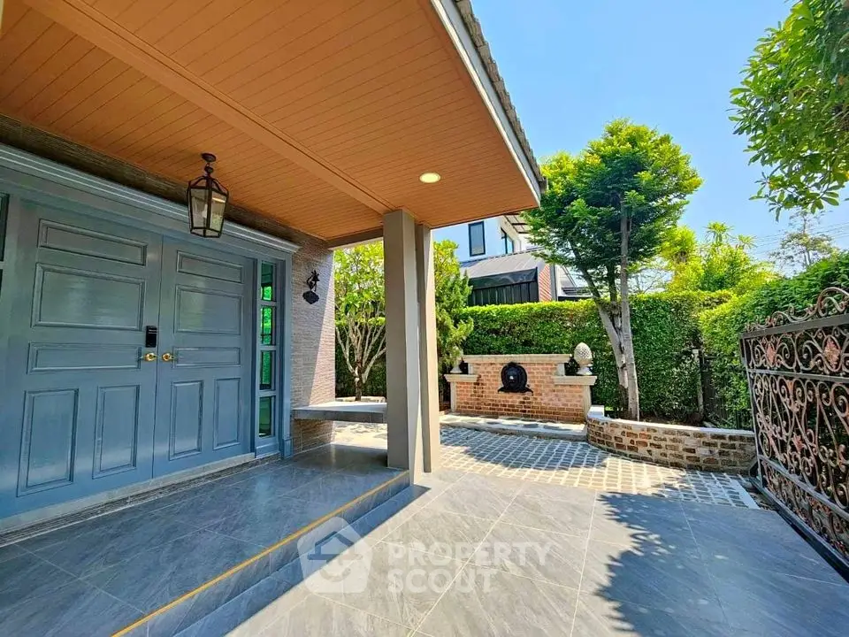 Charming entrance with elegant door and lush garden, perfect for welcoming guests.
