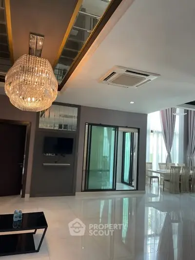 Luxurious modern living room with elegant chandelier and dining area