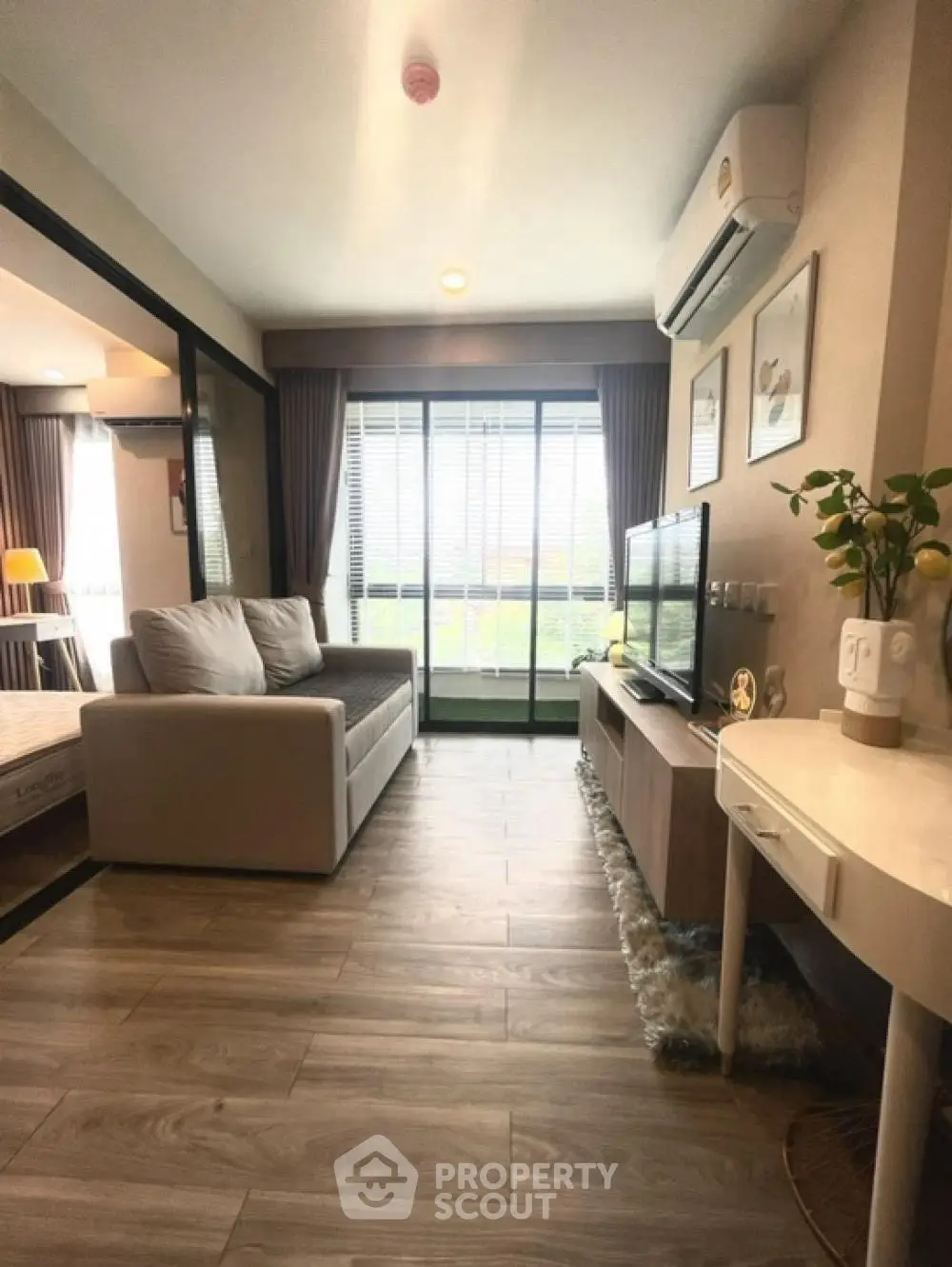 Modern living room with cozy sofa and large window offering natural light.