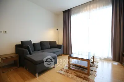 Spacious living room with modern furniture and large window for natural light.