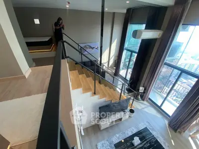 Luxurious duplex apartment with modern interior and stunning city view from large balcony.