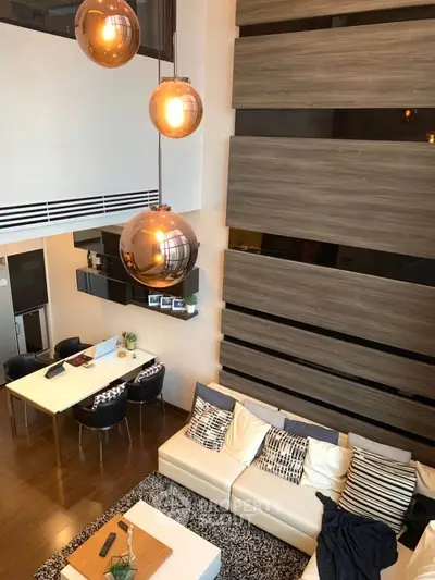 Modern living room with high ceiling and stylish lighting in a contemporary apartment.
