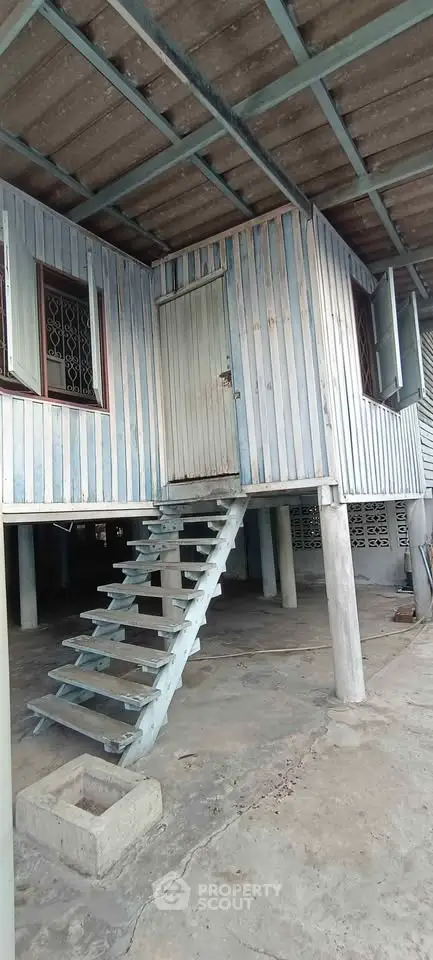 Elevated rustic wooden house with staircase and open window