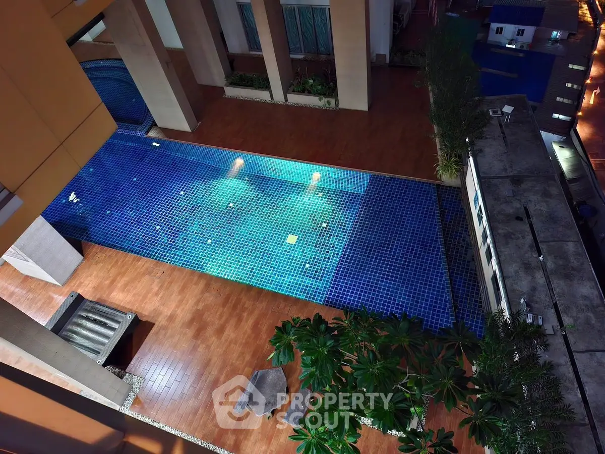 Stunning night view of illuminated swimming pool in modern residential complex.