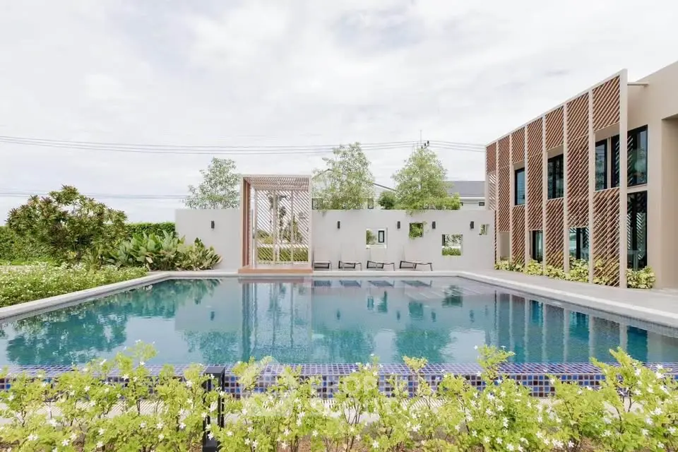 Luxurious modern building with stunning outdoor pool and lush greenery, perfect for relaxation and leisure.
