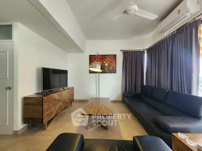 Modern living room with stylish furniture, large TV, and elegant decor, perfect for relaxation and entertainment.
