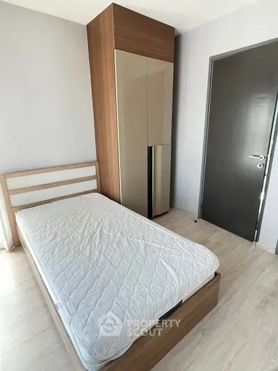 Modern minimalist bedroom with sleek wardrobe and single bed, perfect for urban living.