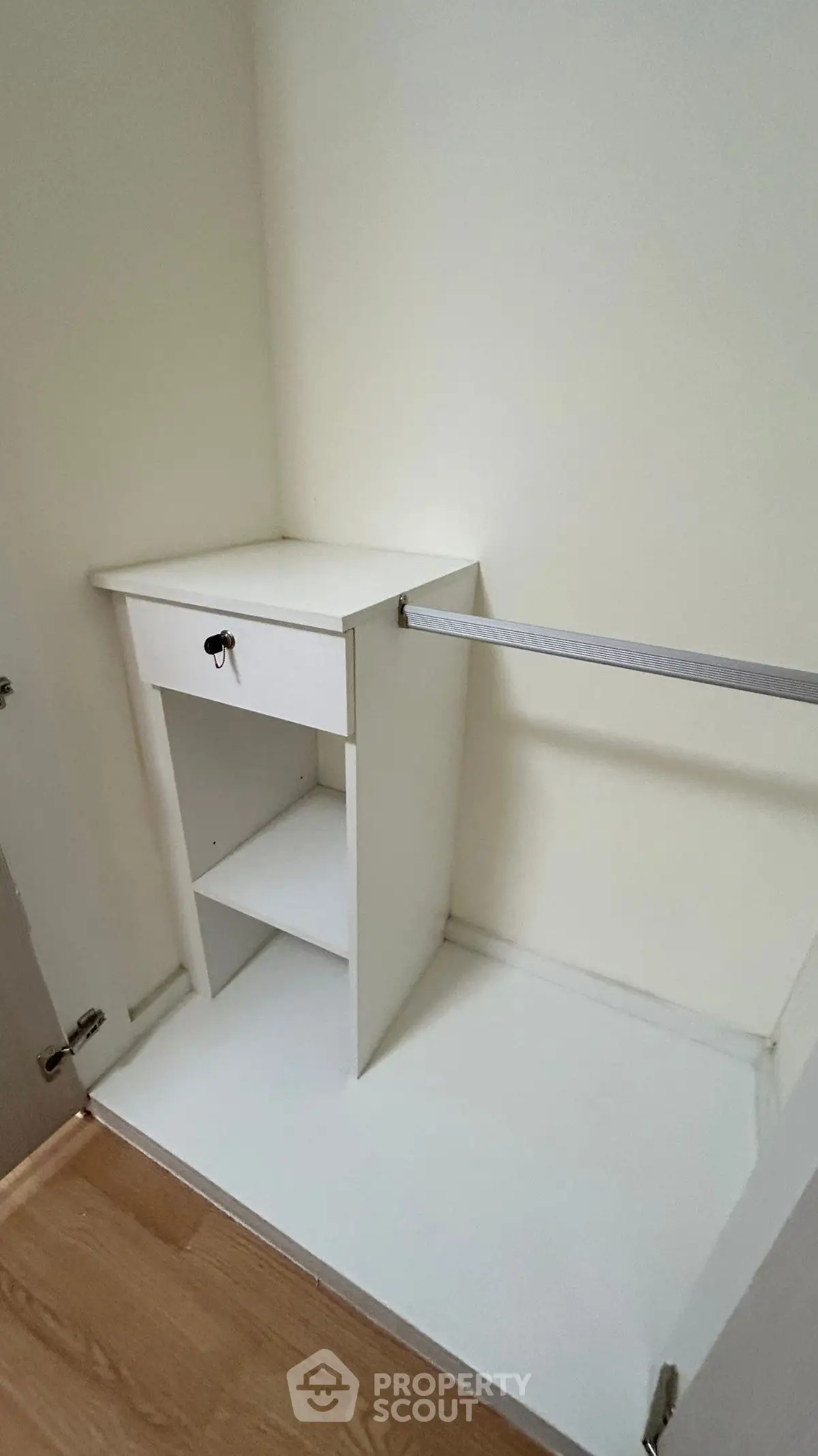 Compact walk-in closet with built-in shelving and hanging rod