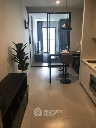 Modern apartment interior with open kitchen and stylish living area, featuring sleek design and natural light.
