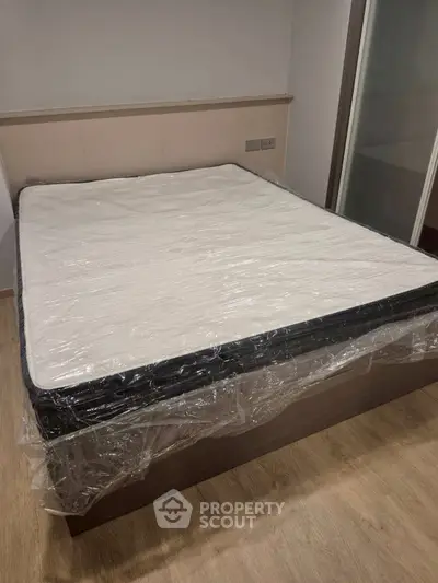Spacious bedroom with new mattress and modern flooring, ideal for comfort and relaxation.