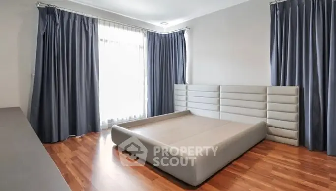 Spacious bedroom with modern bed frame and elegant curtains