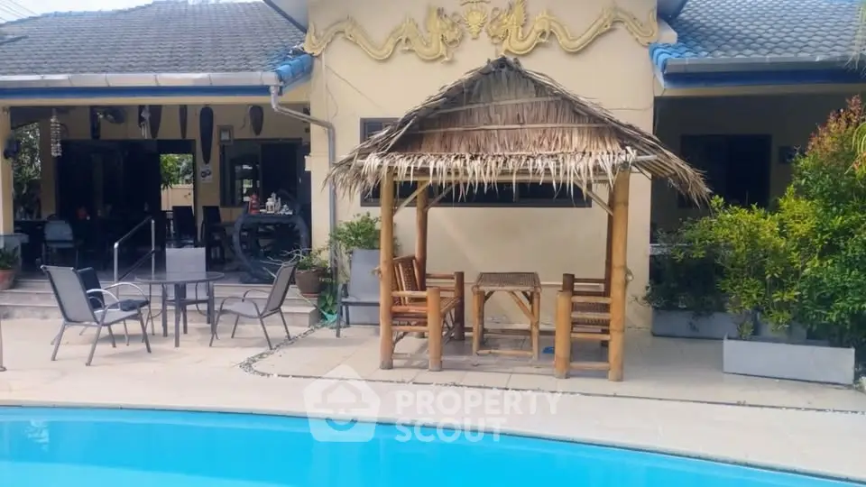 Charming poolside view with rustic bamboo gazebo and lush greenery