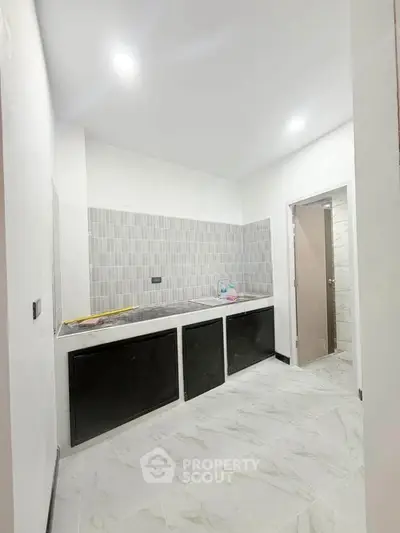 Modern kitchen with sleek cabinetry and tiled backsplash in a bright, minimalist design.