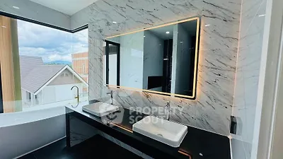 Luxurious bathroom with dual sinks and large mirror in modern home with scenic view.