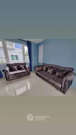 Spacious living room with plush sofas and large windows offering natural light.