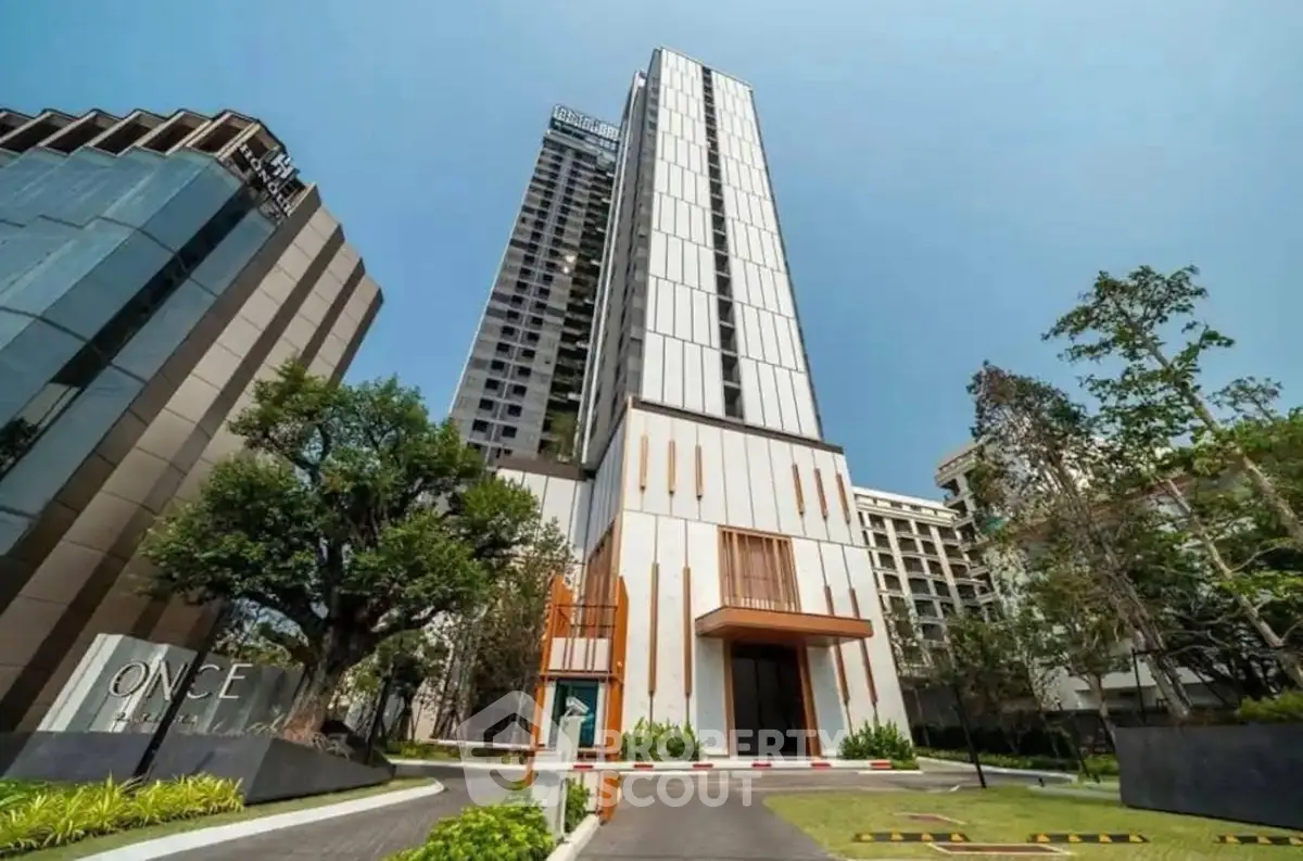 Stunning modern high-rise building with sleek design and lush landscaping in prime urban location.