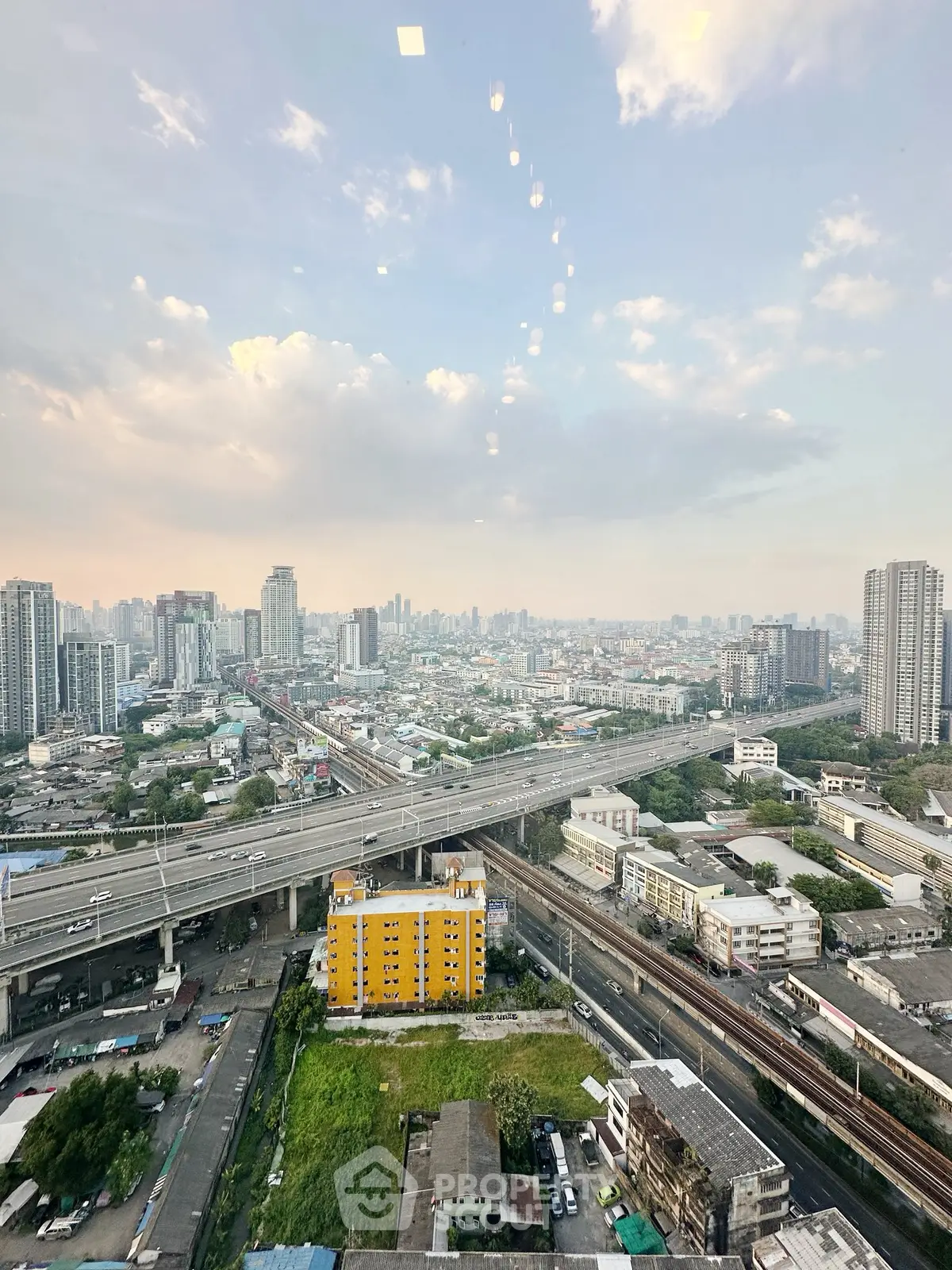 Stunning cityscape view from high-rise building showcasing urban skyline and transportation network.