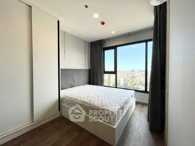 Modern bedroom with city view, featuring large window and minimalist design.