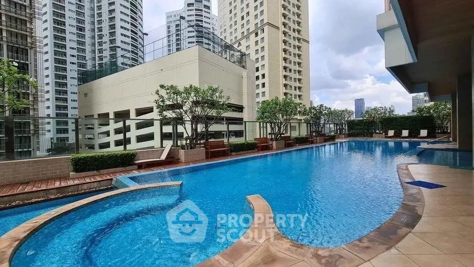 Luxurious rooftop pool with city skyline views in modern high-rise building.