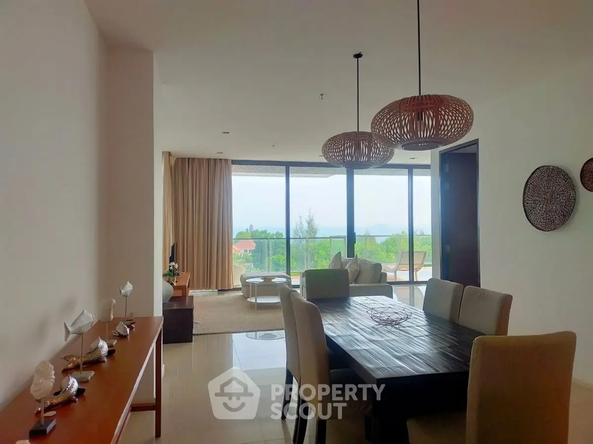 Spacious open-plan living and dining area with large windows and scenic view.