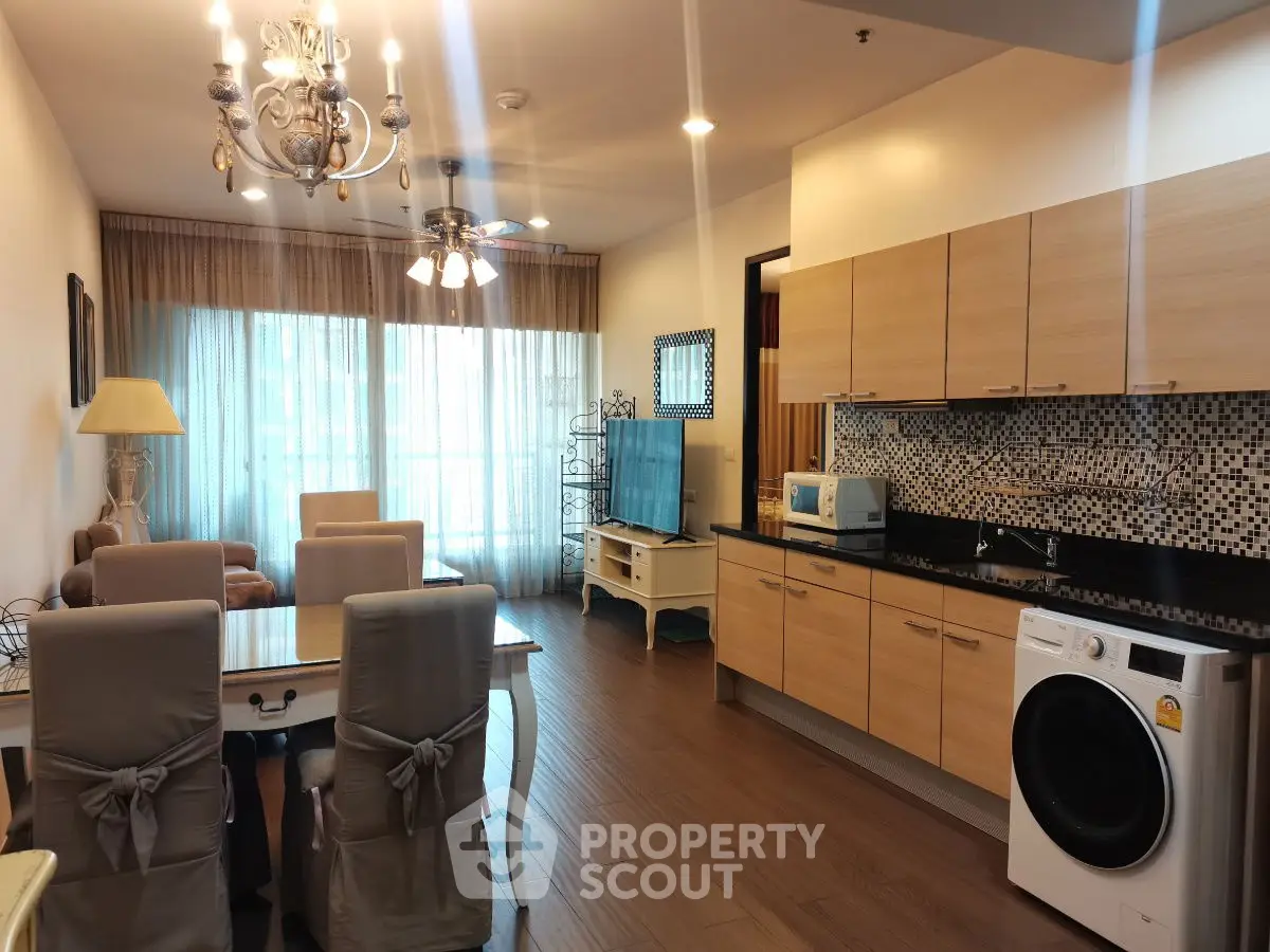 Spacious living room with modern kitchen and elegant decor in a stylish apartment.